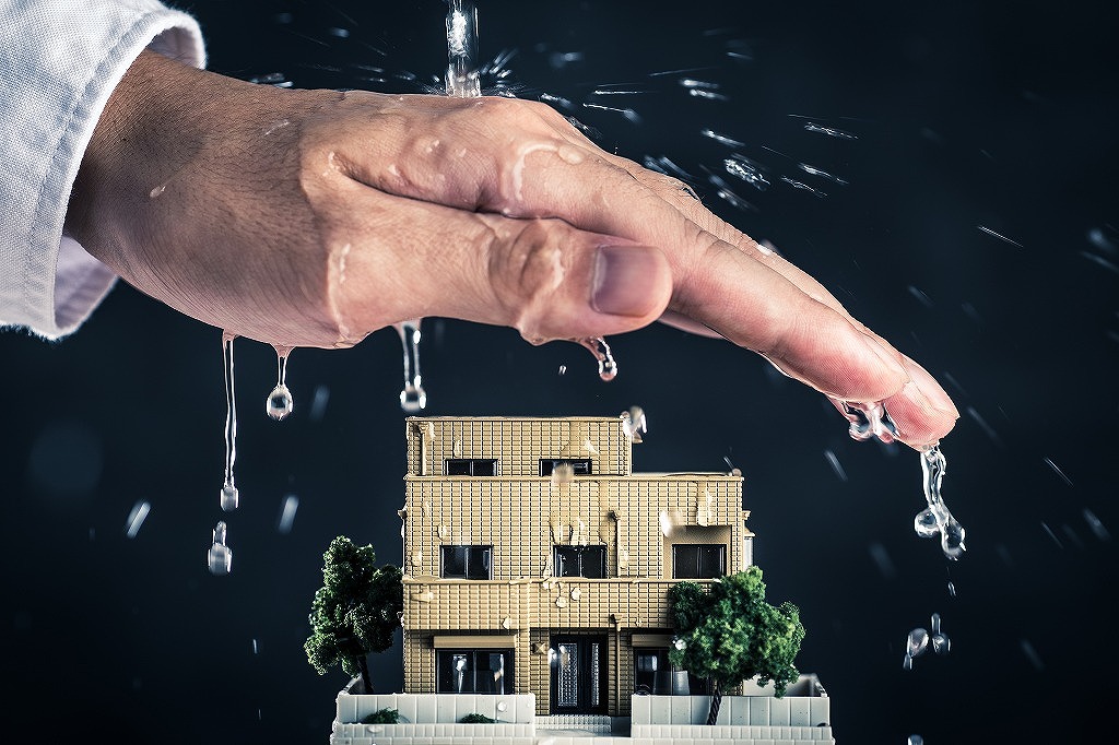 家の模型と手のひらと水